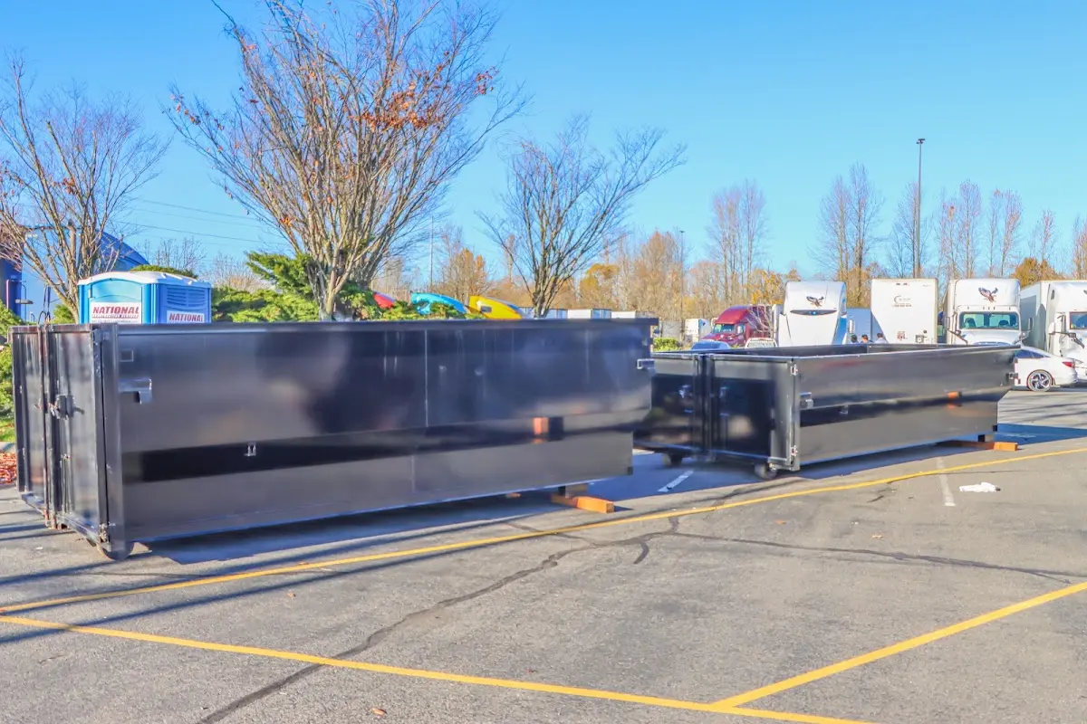 Professional dumpster rental service with roll-off container on residential driveway in Stanton